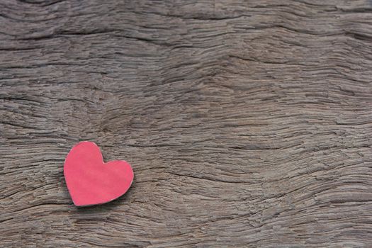 Valentines Day background with red heart shape on dark wooden background with copy space
