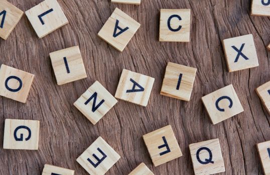 background of letterpress wood type printing blocks on wooden background, random letters of alphabet and punctuation stained by black inks
