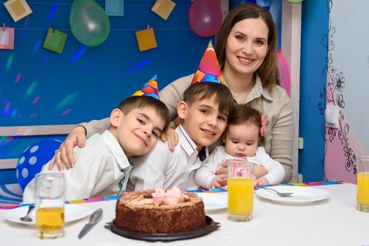 Happy family hugs mom at birthday party