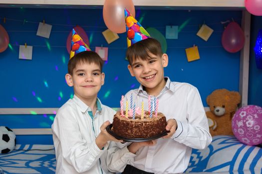 Two brothers hold a holiday cake at a holiday