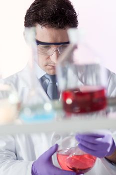 Chemist in chemical laboratory searching for the red indicating solution.
