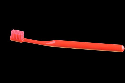 Red toothbrush isolated on the black background