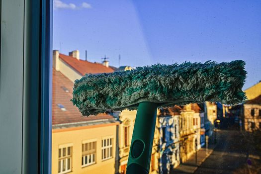 Cleaning windows with a squeegee. Cleaning concept. Washing window, close up. Looking through window