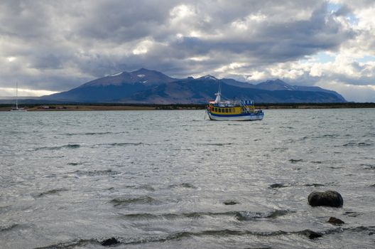 Tourist boat in the Ultima Esperanza Inlet and Sarmiento Mountain Range from Puerto Natales. Ultima Esperanza Province. Magallanes and Chilean Antarctic Region. Chile.