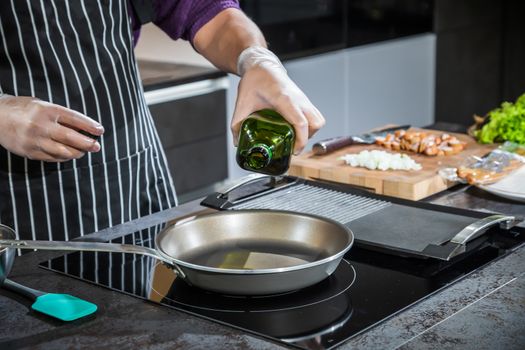 Cook pours vegetable oil in a pan for frying foods