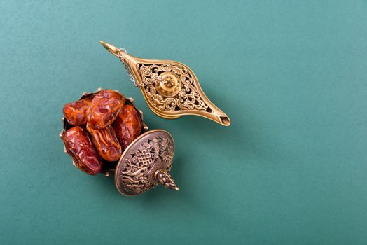 Ramadan, Dates in golden bowl and have arabian Aladdin golden lamp vintage style on black green background