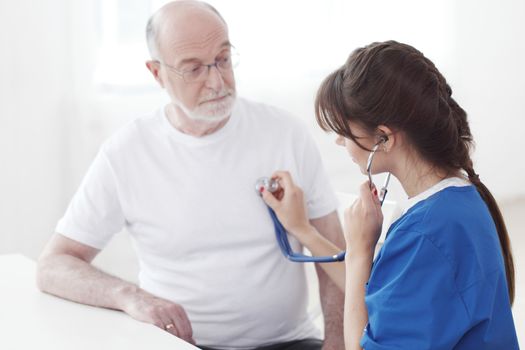 Doctor Examining Senior Male Patient In Hospital, listening heartbeat, cardiology