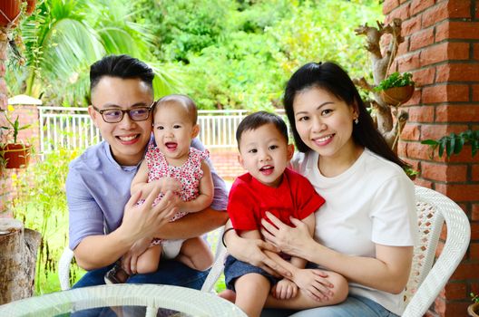 asian family relaxing at garden outside the house