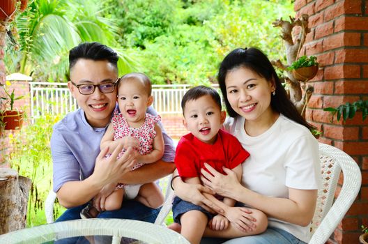 asian family relaxing at garden outside the house