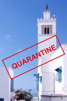 Text of the quarantine against the background of the blue-and-white city of Sidi Bou Said in Tunisia, tourist attractions are closed due to a new outbreak of coronavirus. The concept of the collapse of the tourism industry.