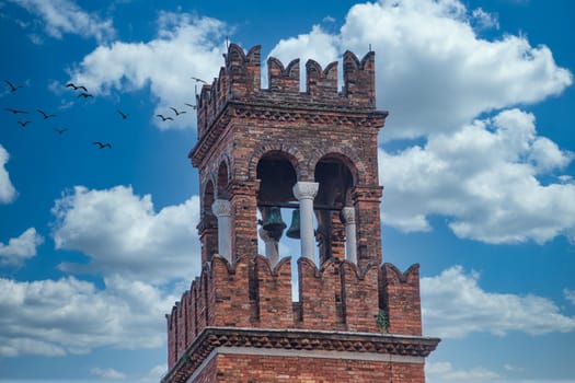 A brick bell tower against the sky in Venice