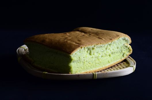 Pandanus   sponge cake  on wooden basket isolated on black background