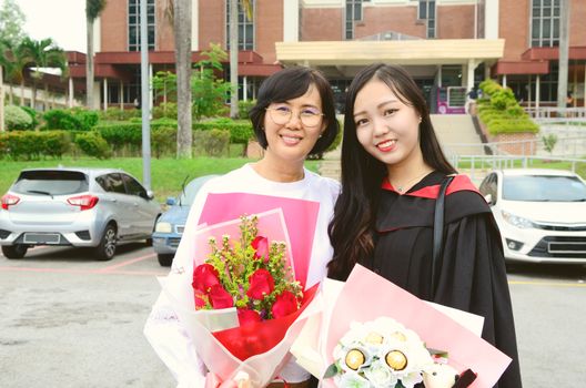 Asian university student and mother celebrating graduation