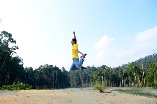 Man jumping with joy by a lake