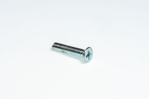 Detail of a small steel screw on a white background