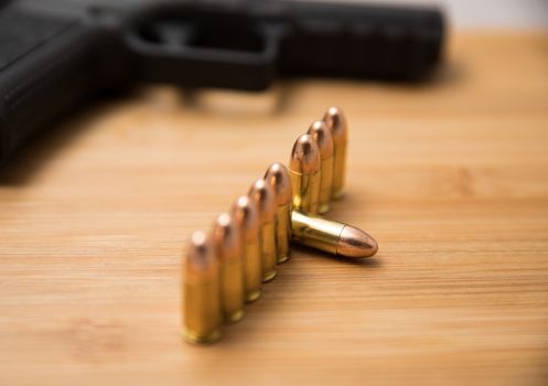 Row of 9mm bullets also showing a gun in the background