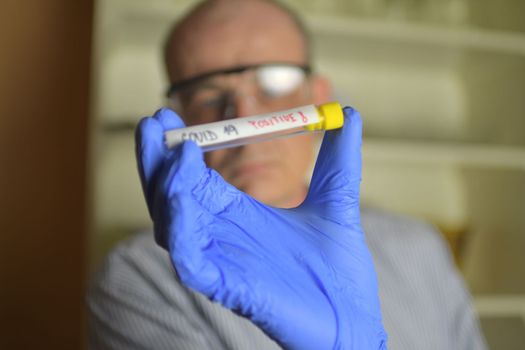 Doctor holds COVID 19 Coronavirus vaccine in his hand, infected sample in the sample tube, Vaccine and syringe injection It use for prevention, immunization and treatment from COVID-19