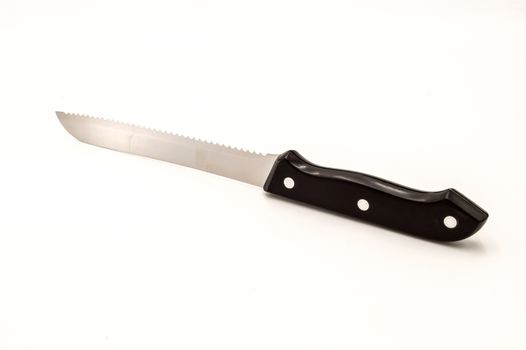 Chromium sawtooth knife with a black handle on a white background