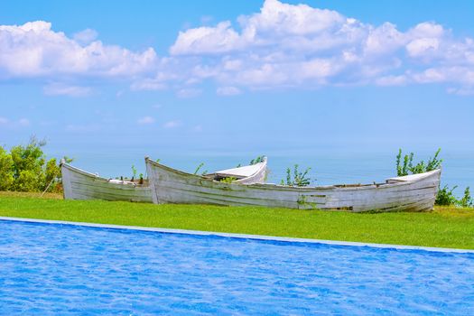 Two Old Boats between Swimming Pool and Sea