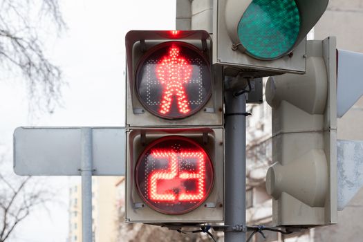 The traffic light shows red, which prohibits traffic for people. Caution sign. Blurred background of the street and the light of day.