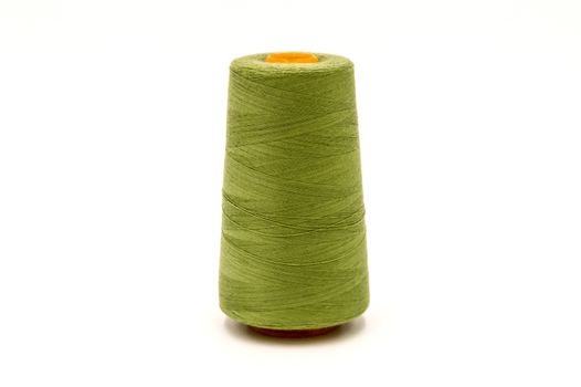 Close up of spool of colored thread on white background