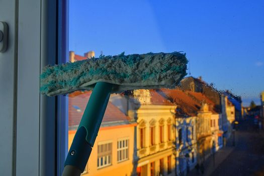 Cleaning windows with a squeegee. Cleaning concept. Washing window, close up