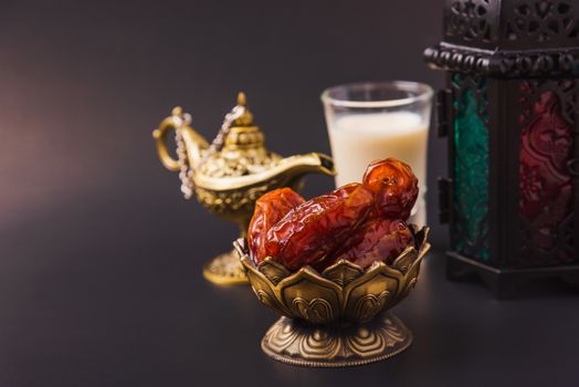 Ramadan Kareem fasting Food Concept, Bronze plate dates, milk, and lantern Aladdin lamp decoration, eid Arabian Muslim religious festival on a black background with copy space for text