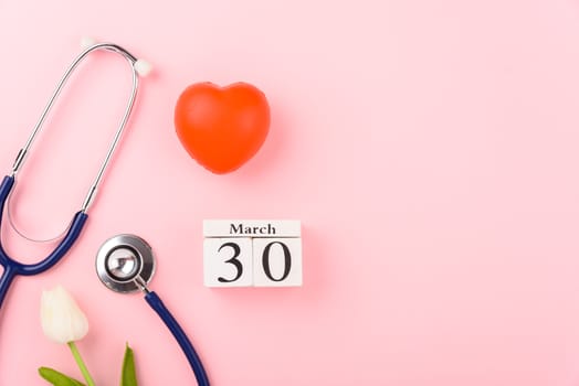 Doctor's Day concept, flat lay top view, equipment medical red heart and stethoscope on pink background, care patient in hospital with copy space for text