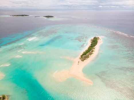 Picture perfect beach and turquoise lagoon on small tropical island on Maldives.