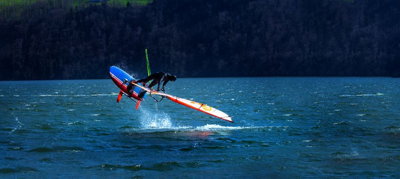 Lifestyle windsurfer on lake Alpnach in Switzerland during a windy spring day