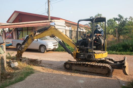 Yellow excavator machine working earth moving works at construction site
