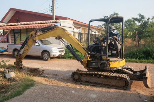 Yellow excavator machine working earth moving works at construction site
