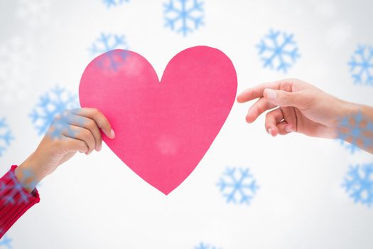 Composite image of Woman passing man pink heart with snowflakes