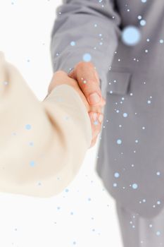 Composite image of People shaking hands with snow falling