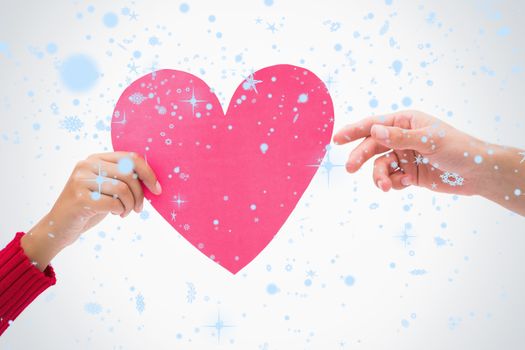 Composite image of Woman passing man pink heart with snow falling