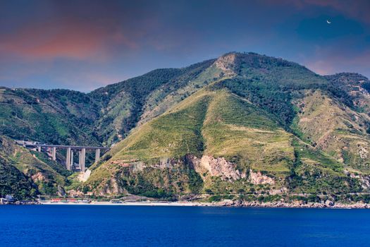 Green Hills and Bridge Over Deep Blue Water in Mediterranean