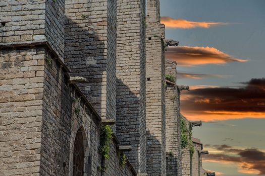 Ancient stone walls and arched windows of a medieval church in Spain