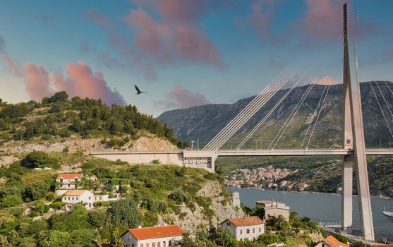 Modern suspension bridge over old homes with red roofs in Dubrovnik