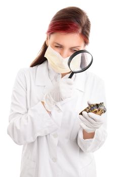 Young female veterinarian in white lab coat, surgical mask and latex gloves, examining a turtle with magnifying glass, isolated on white background.