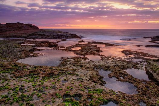 Coastal dawn skies with low tide exposing the rocky reef