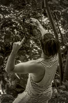 Boy takes a selfie in the woods, image in black and white