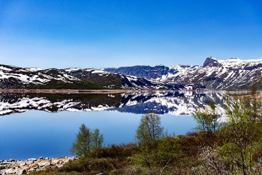 View on mountain lake with reflections in Norway