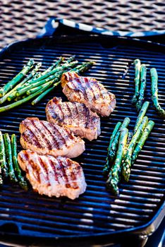 Pork chops and asparagus on grill surface