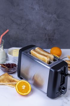 Slices of great toast coming out of the toaster. Healthy breakfast food and heating technology concept.  Focus on slice of great.