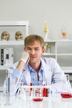 A young Brazilian scientist is tired after completing his research. Working atmosphere in chemical laboratory. Invented a vaccine to prevent Coronavirus 2019 (COVID-19) in a science lab.