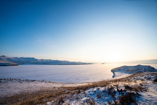 Sunset scene at Ogoy Island. Frozen ice Lake Landscape. Lake Baikal, Russia