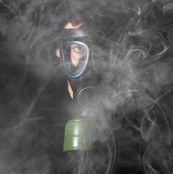 Man in a gas mask in the smoke, black