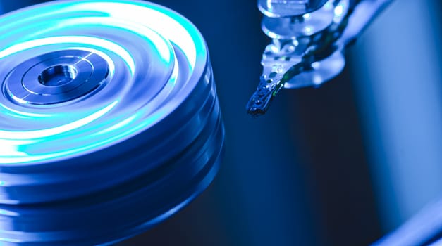 Detail of the inside of a hard disk with the reading head in operation, blue light image