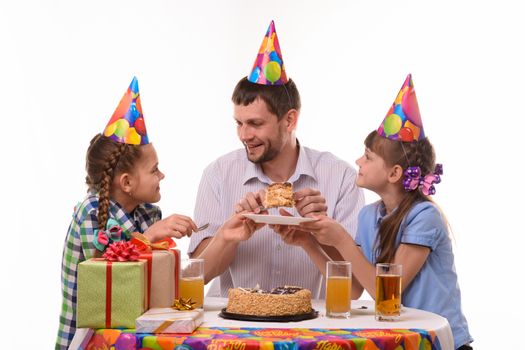 Dad puts a piece of holiday cake on a plate and looks at his daughter