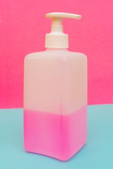 Antibacterial disinfectant soap. Liquid pink soap in white bottle.